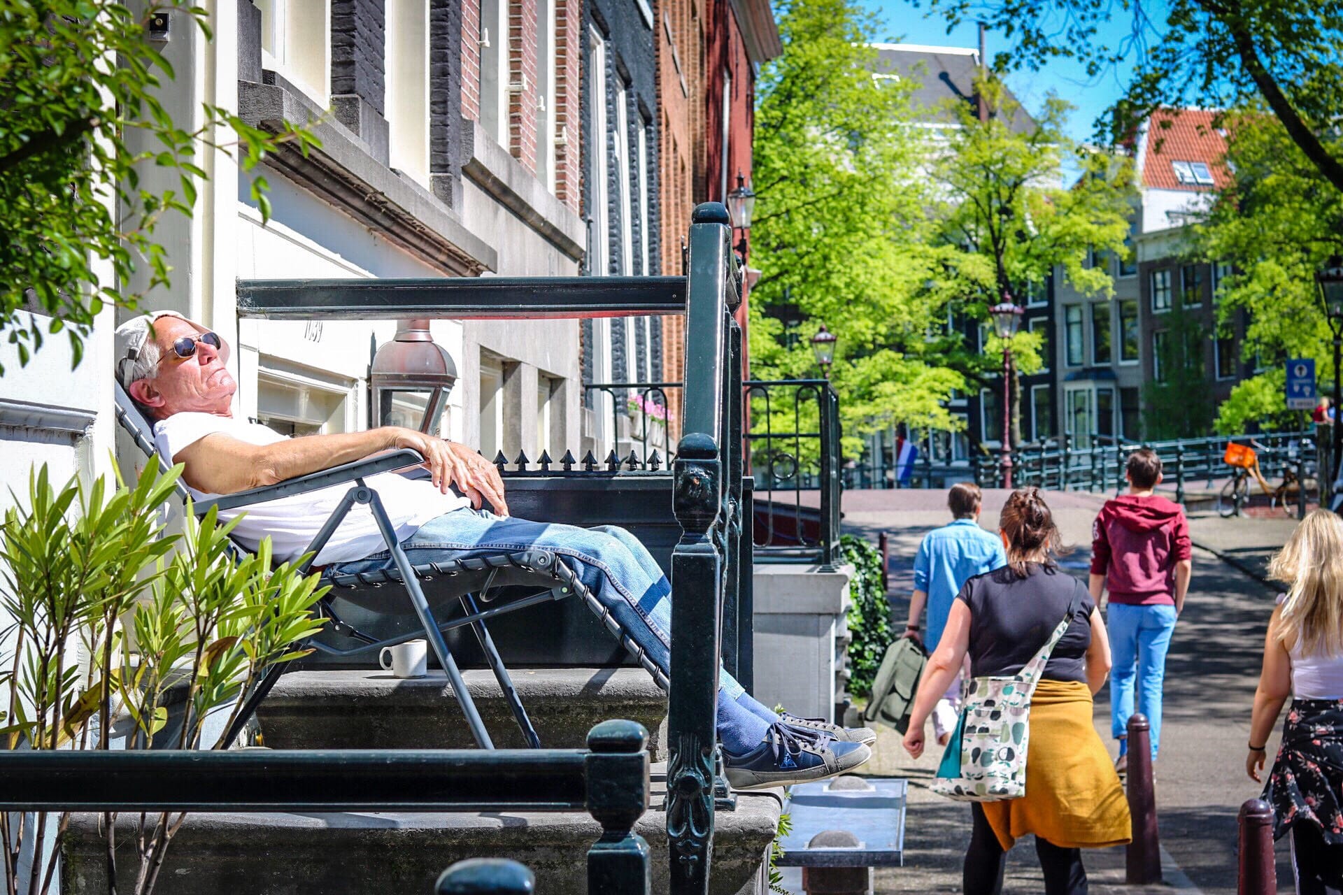 Man reclining in front of his house, enjoying the sun