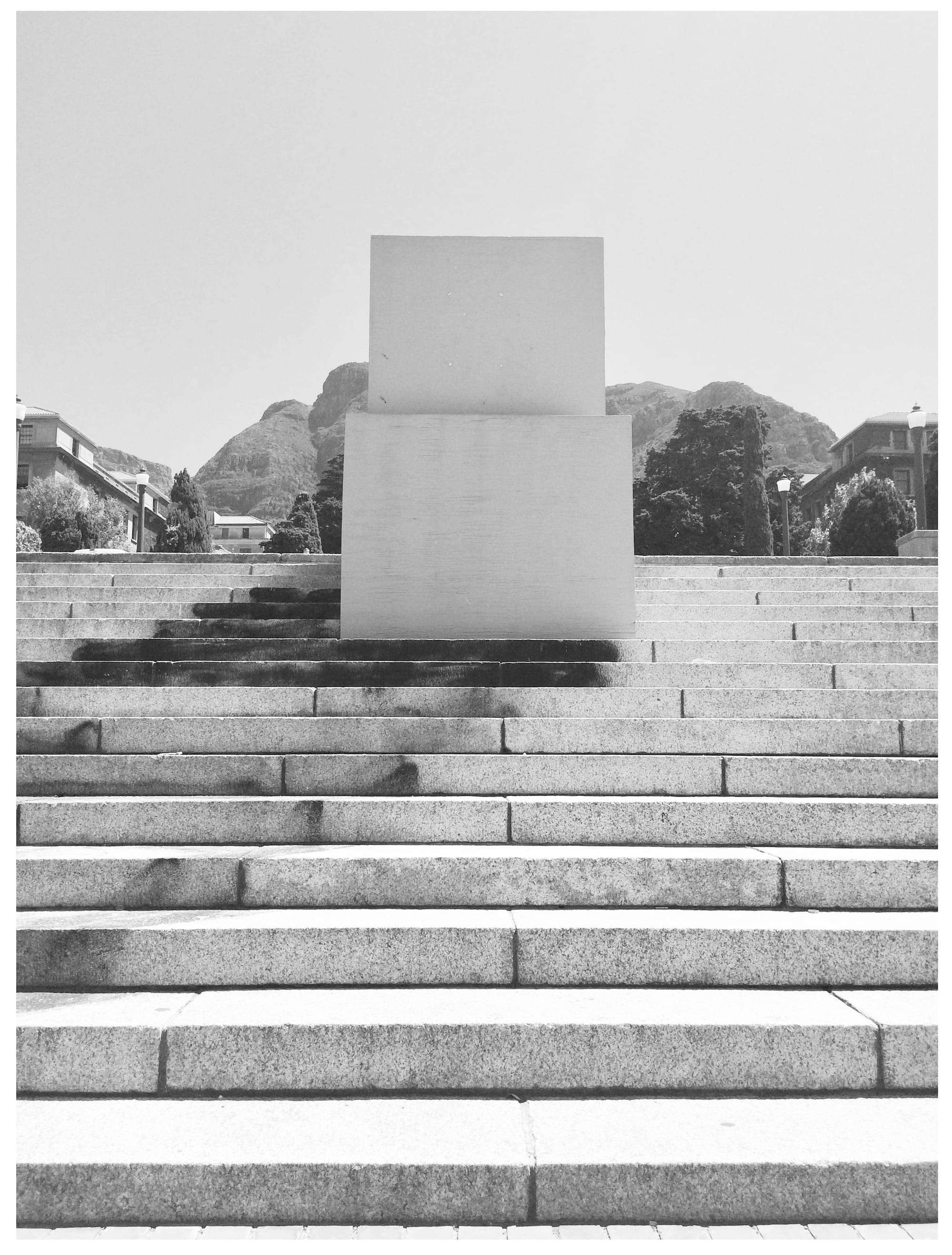 Black and white photo of the empty and boxed-up pedestal where the statue of Rhodes once stood