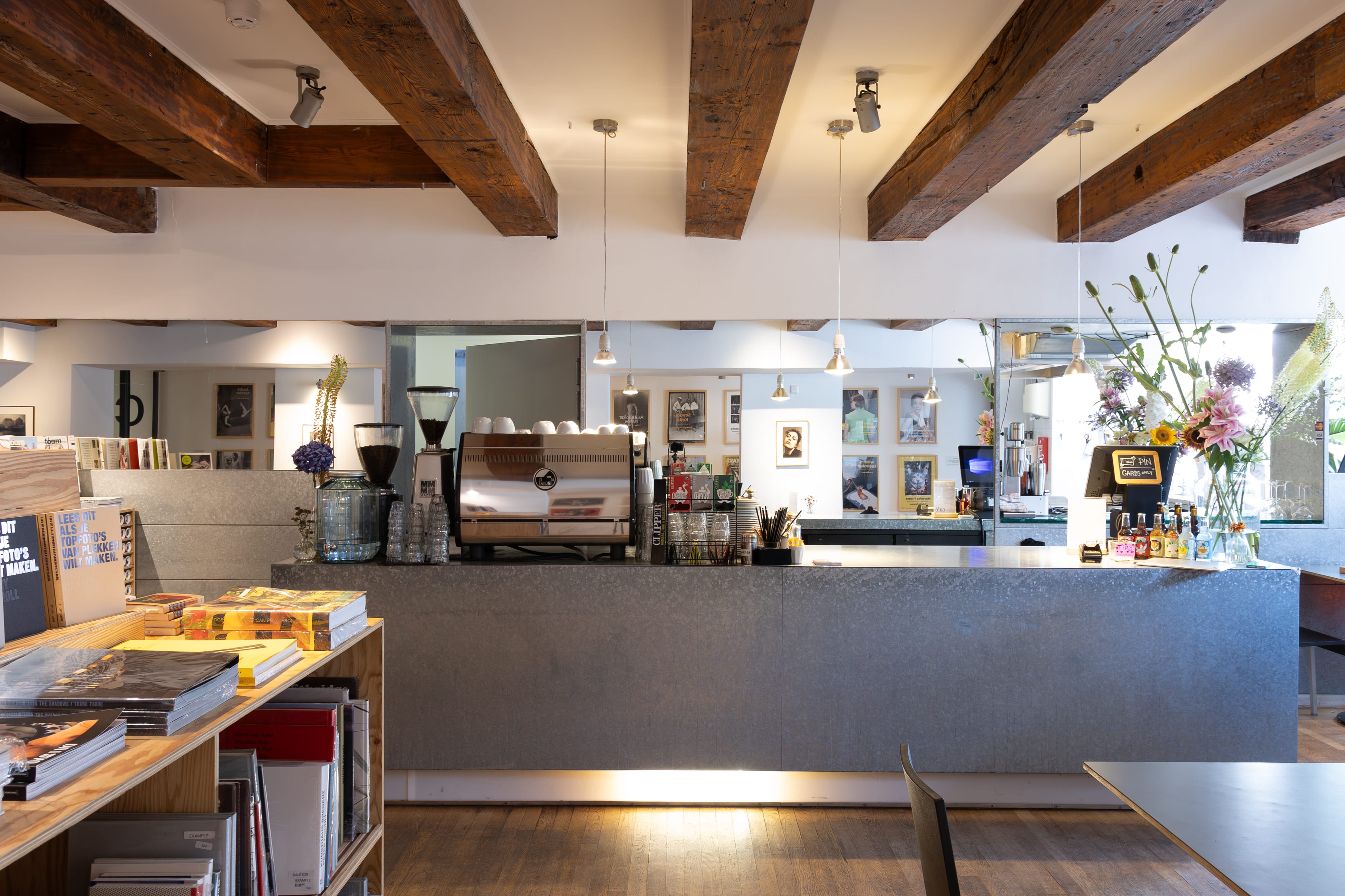 Cozy bar with wooden ceiling and floor and a selection of books on the side.