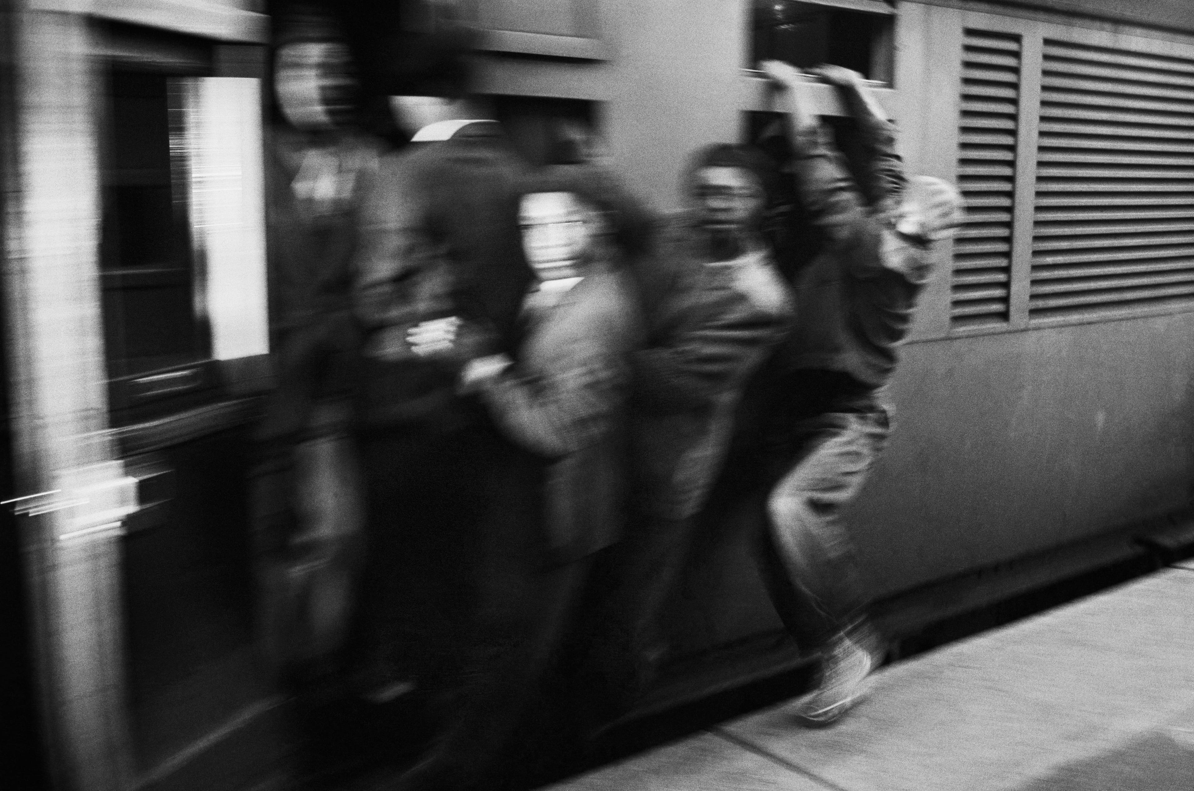 group of men grabbing onto train