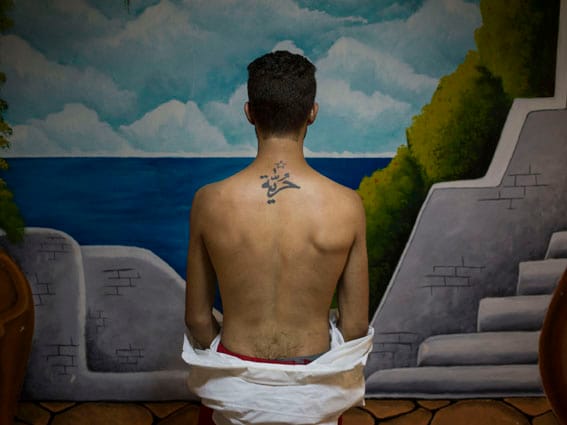 A young actor working with the Fani Raghman Ani group, an association defending human rights in Tunisia, showing a taffoo on his back saying ’freedom’ in Arabic. Tunis, Tunisia, 2017 C Newsha Tavakolian / Magnum Photos.