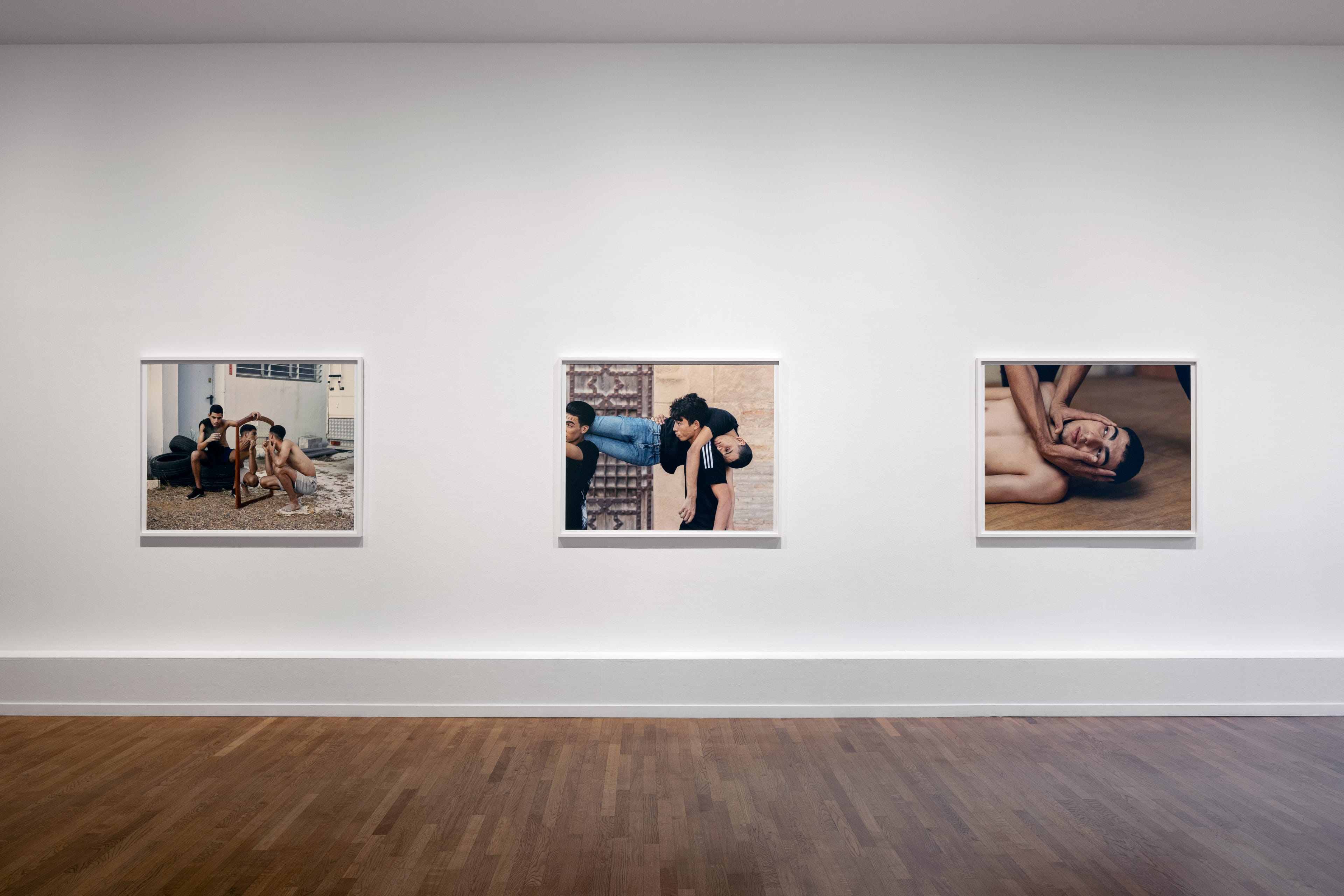 Image of photos hanging in a white exhibition space