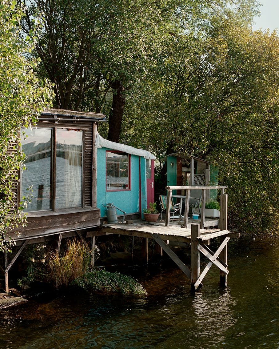 House with mirrors a blue wall and a pink door on the lake 